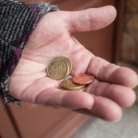 closeup of euros coins in hand of poor woman